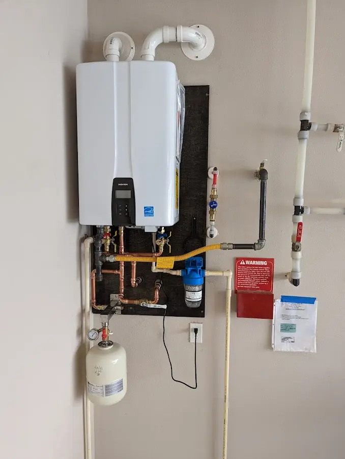 Professional plumber installing copper piping in a Byram home